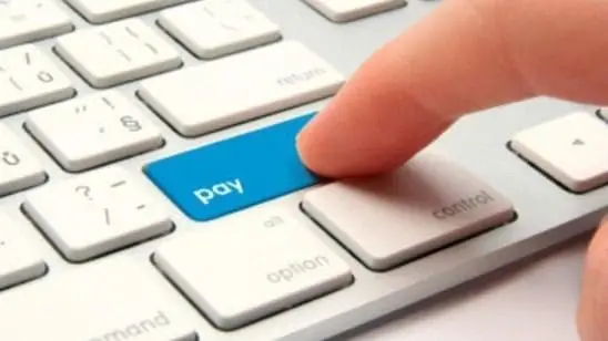 a finger pressing a blue button on a keyboard