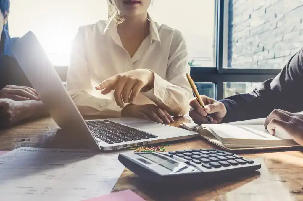 man and woman pointing at computer