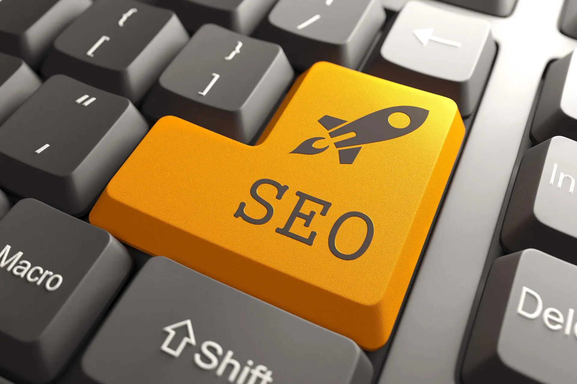 Keyboard with orange SEO button highlighting natural search engine optimization