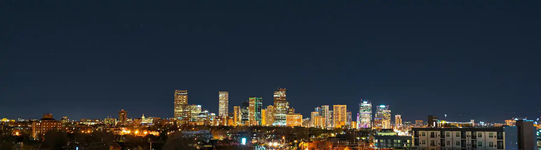 Downtown Denver skyline lit up at night, home of Creative Options Marketing