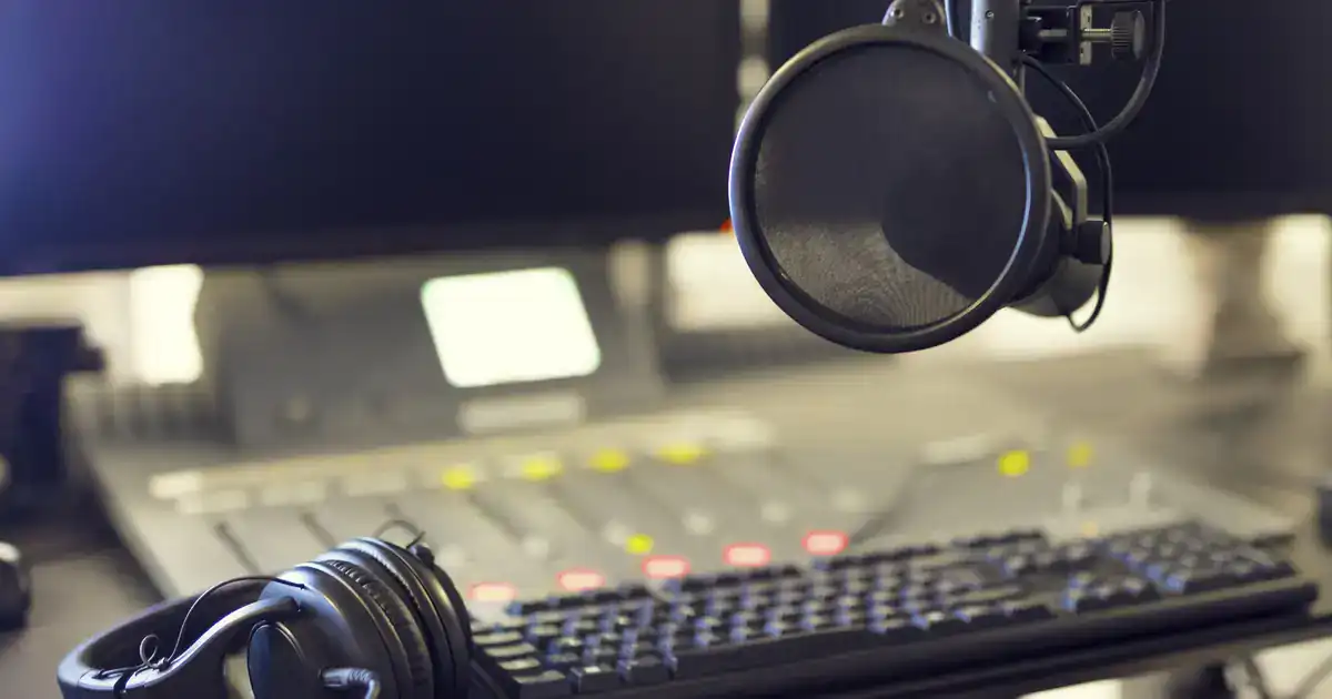 Radio station studio with microphone, headphones and mixing board lights